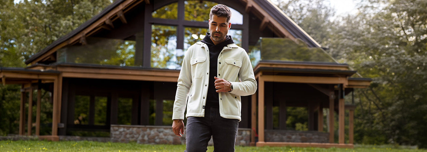 Modèle homme portant une surchemise bleu clair dans un décor architectural moderne. Surchemises Au Noir idéales pour superposer avec style lors des saisons intermédiaires.