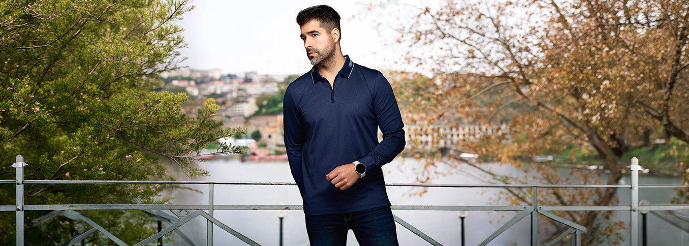 Modèle homme portant un polo à motif géométrique sur un terrain de golf entouré d'arbres. Polos Au Noir confortables et élégants pour un look sport chic moderne.