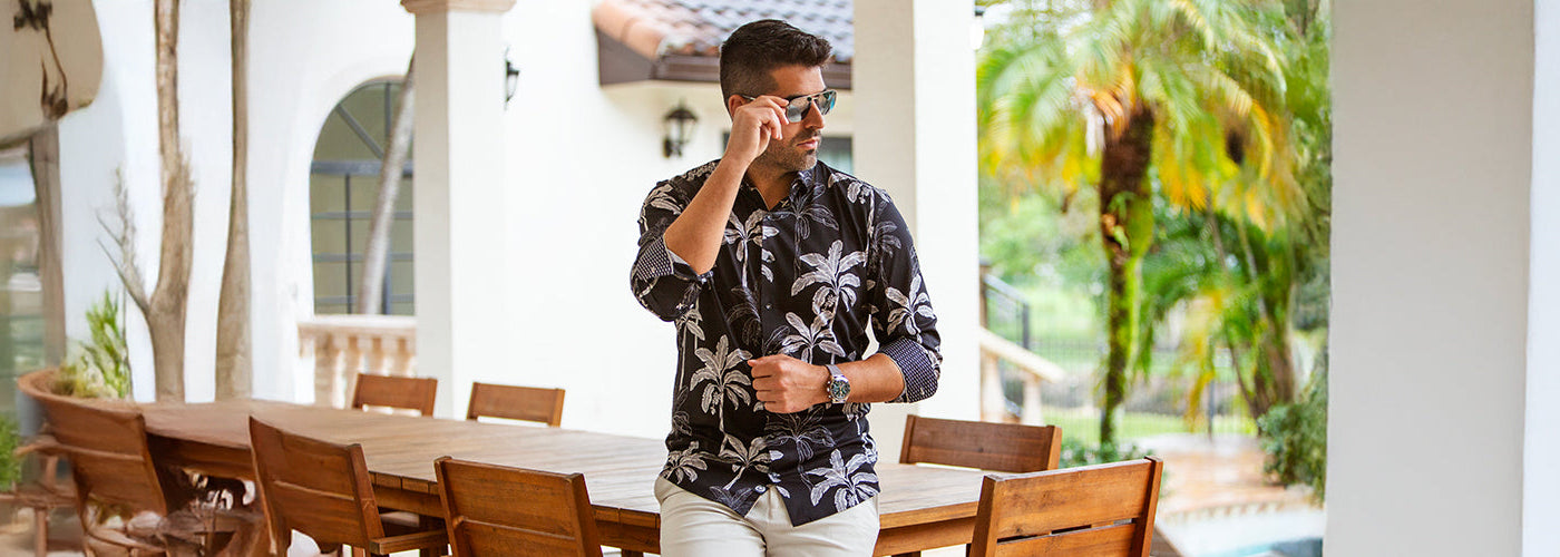 Modèle homme portant une chemise M.L. blanche élégante devant une maison moderne avec voiture sportive. Chemises Au Noir raffinées conçues pour un style chic et une silhouette élégante.