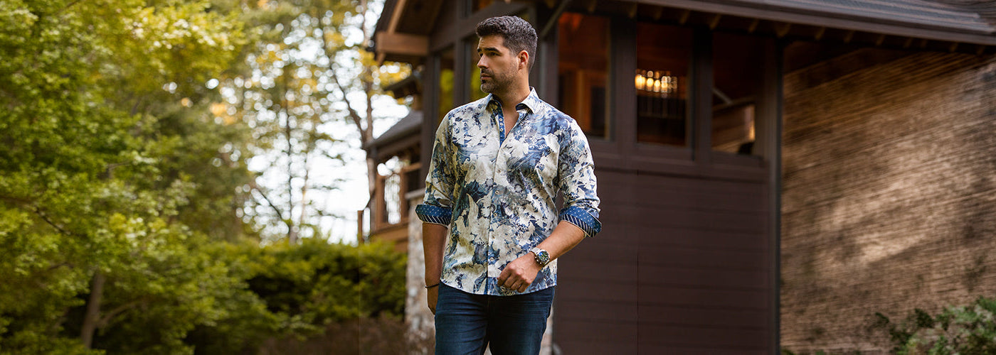 Modèle homme portant une chemise M.L. blanche élégante devant une maison moderne avec voiture sportive. Chemises Au Noir raffinées conçues pour un style chic et une silhouette élégante.
