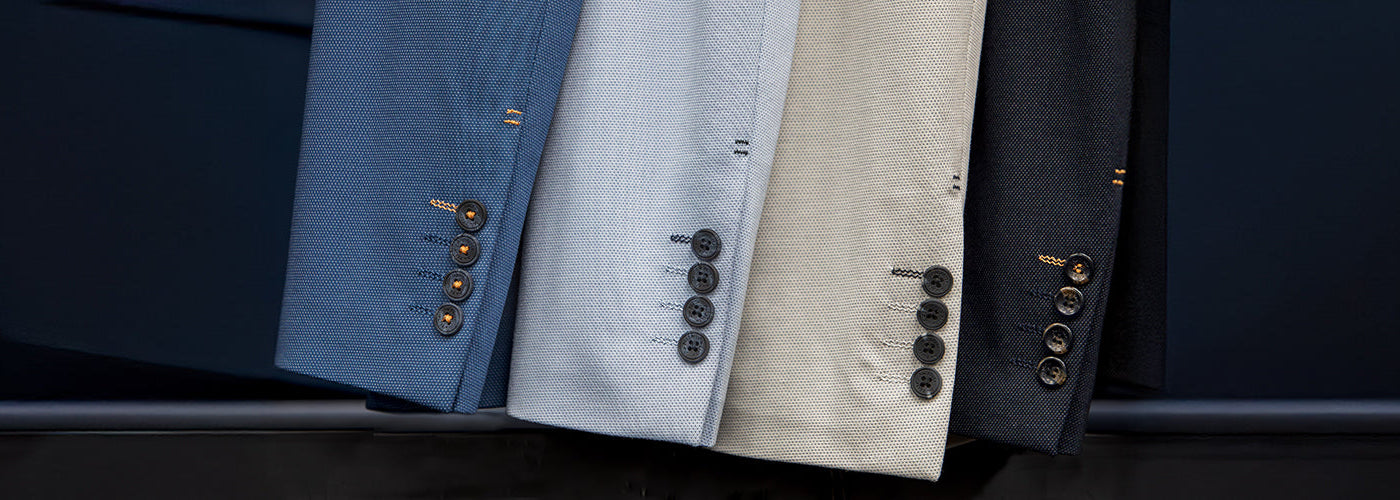 Présentation de plusieurs Blazers Au Noir alignés montrant les manches et boutons signature. Blazers Au Noir élégants conçus avec tissus premium et finition raffinée.