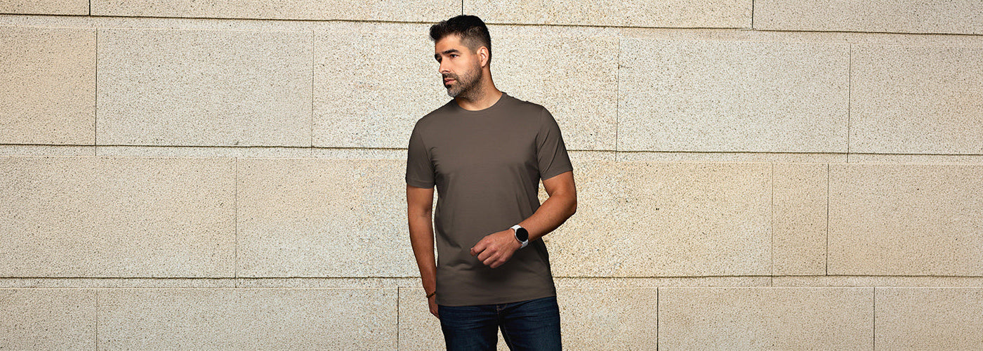 Modèle homme portant un Knit sweater mérino bicolore dans un décor automnal avec arbres colorés. Chandails Au Noir en laine mérino offrant chaleur, confort et élégance.