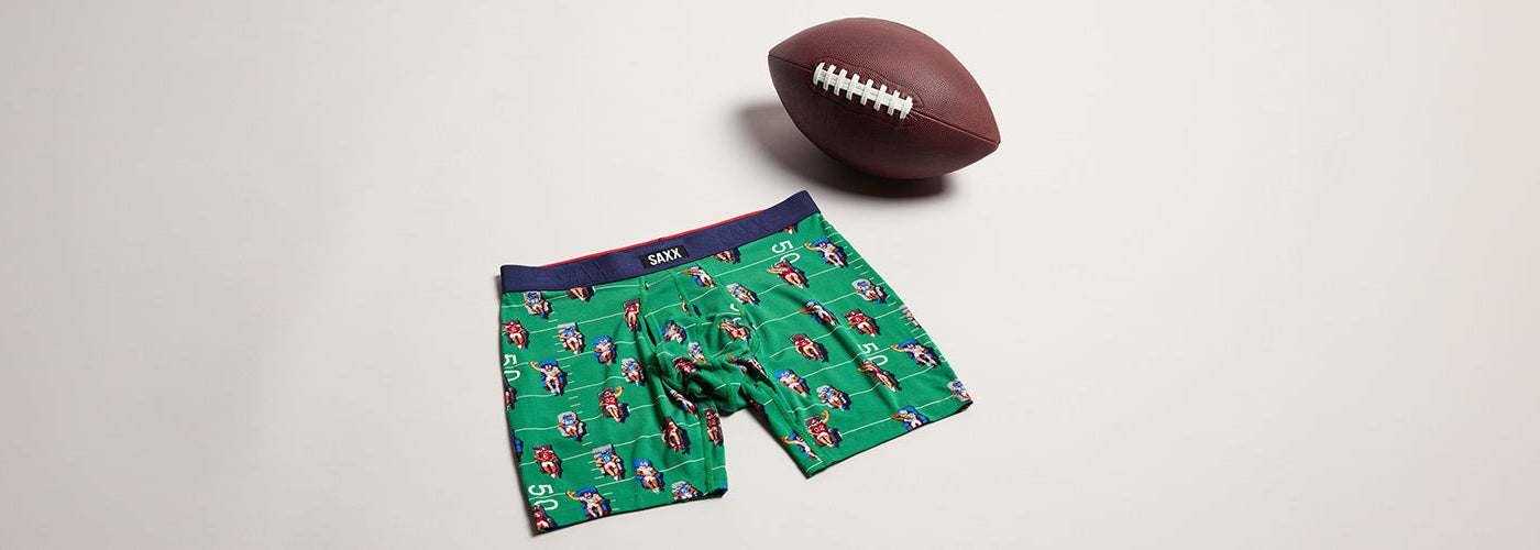 Boxer SAXX vert à imprimé football présenté avec un ballon, sous vêtement pour homme de la collection SAXX.