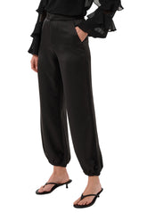 Cream women's black satin-look jogger pants with side pocket and gathered elastic hems, front view