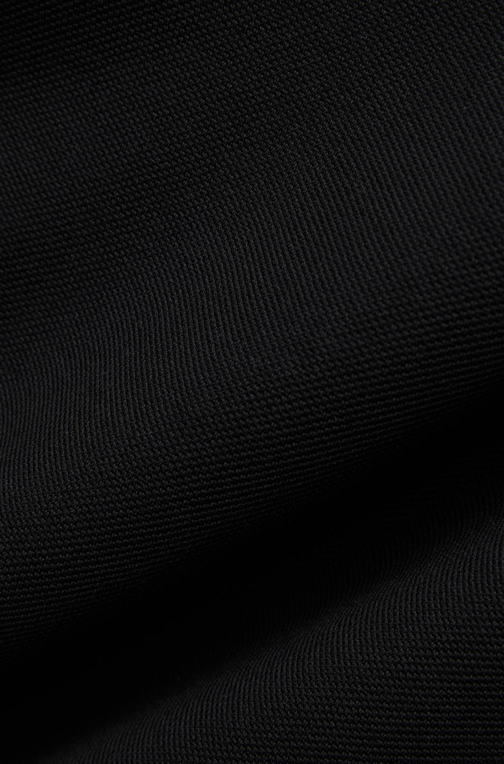 Tissu tricoté noir texturé montrant une surface côtelée fine et plis pour homme par Psycho Bunny, en gros plan