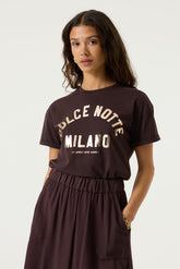 Women's close front model view of dark plum crewneck Short-sleeve T-Shirt with gold Milano lettering by Garcia