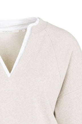 Gros plan du chandail manches longues beige pâle avec col fendu, bordure blanche et encolure côtelée pour femme par YAYA