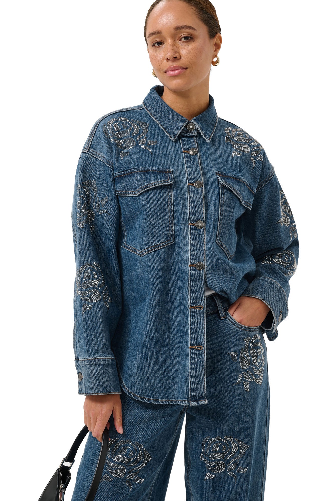 Vue avant en angle du blouse manches longues en denim bleu avec poches à rabat et roses en strass pour femme par Kaffe