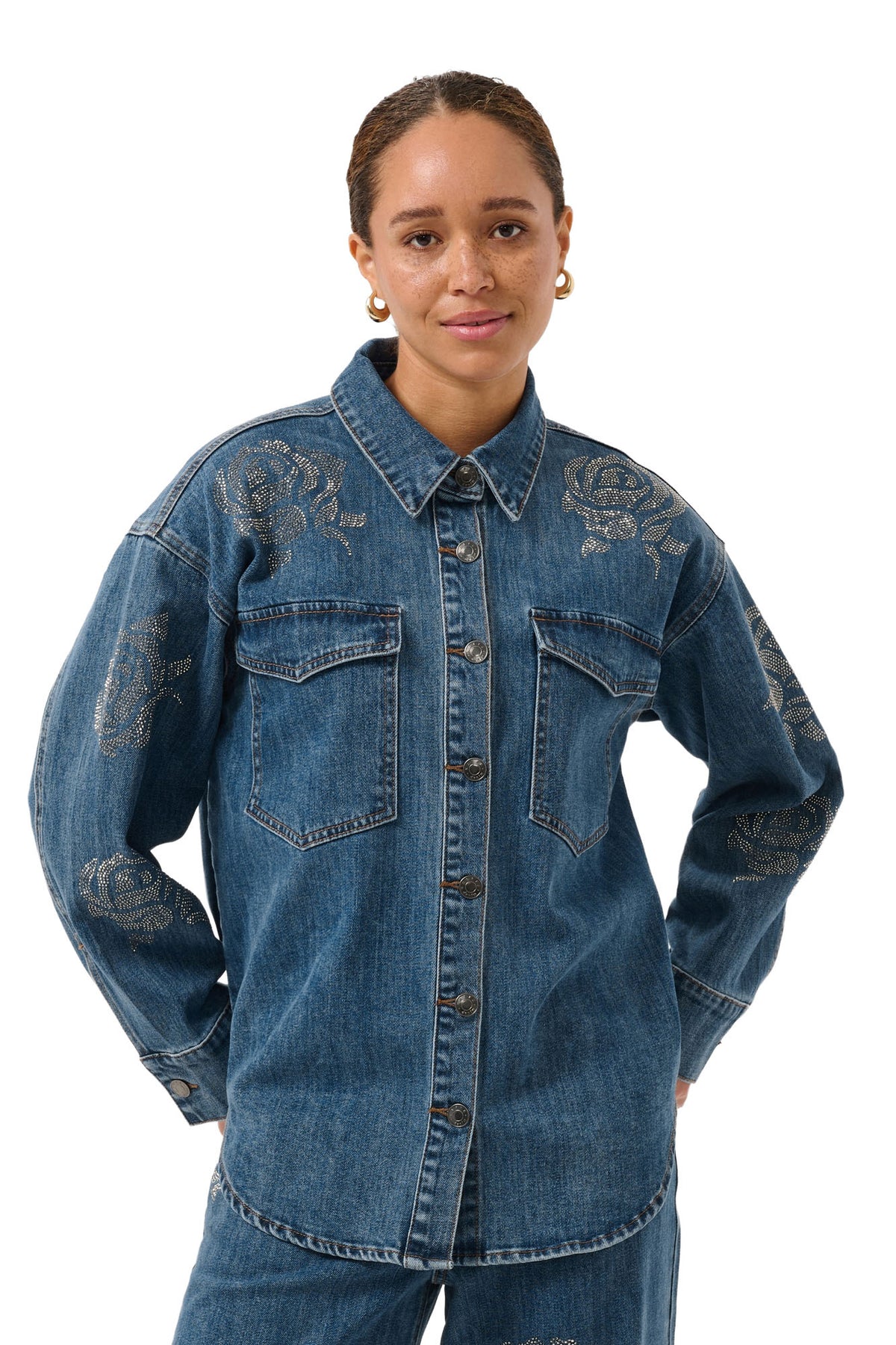 Blouse manches longues en denim bleu avec poches à rabat et roses en strass pour femme par Kaffe, vue avant sur mannequin