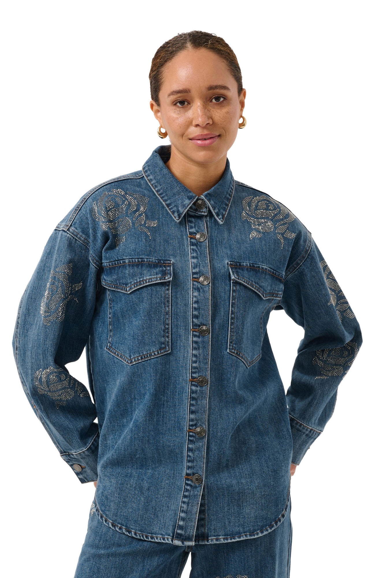 Blouse manches longues en denim bleu avec poches à rabat et roses en strass pour femme par Kaffe, vue avant sur mannequin