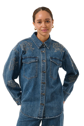 Blouse manches longues en denim bleu avec poches à rabat et roses en strass pour femme par Kaffe, vue avant sur mannequin