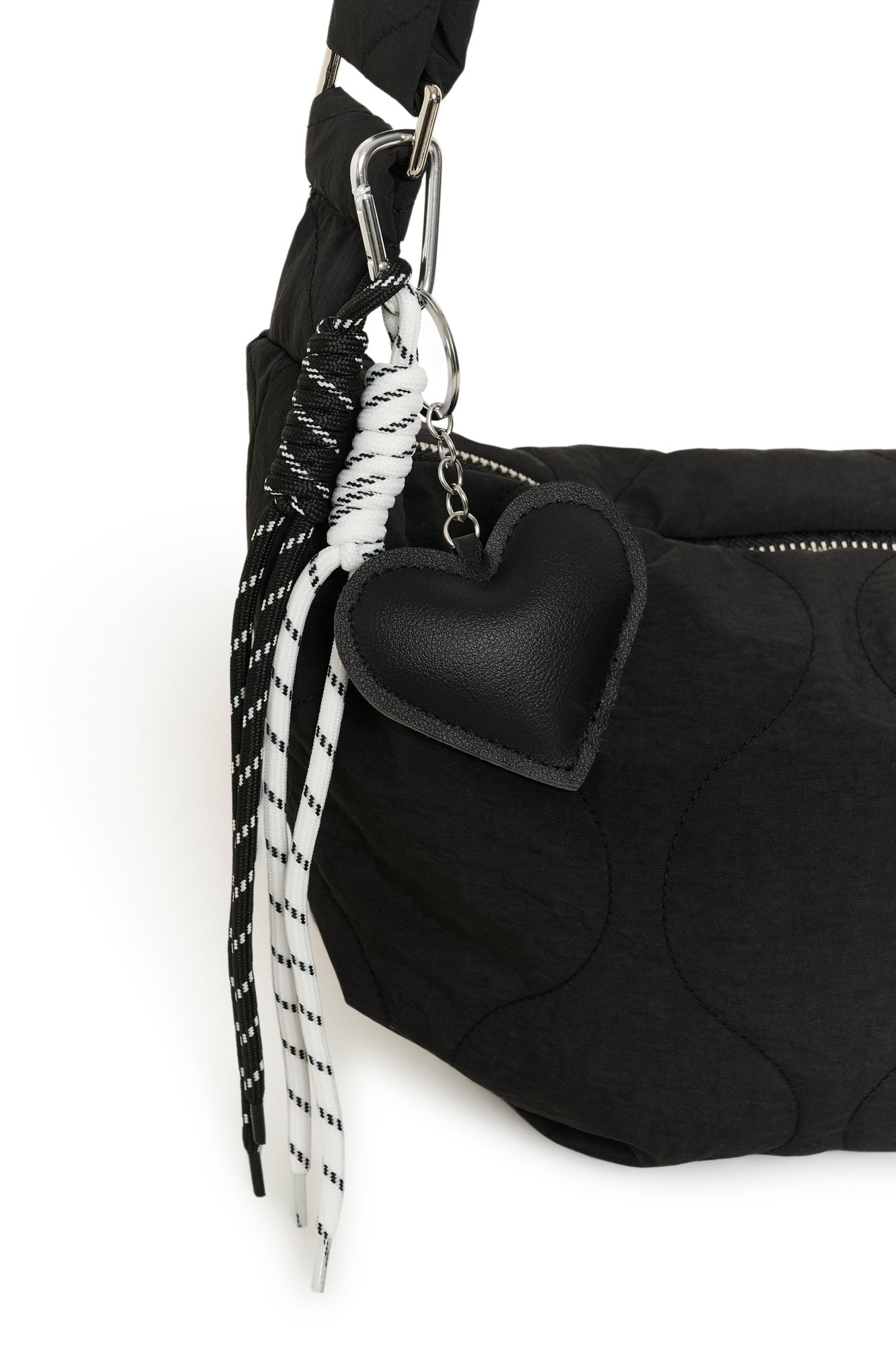 Quincaillerie de la sac à bandoulière noir matelassée avec coeur et cordons noir et blanc pour femme par Kaffe en gros plan