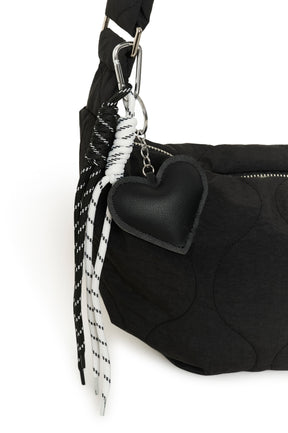 Quincaillerie de la sac à bandoulière noir matelassée avec coeur et cordons noir et blanc pour femme par Kaffe en gros plan