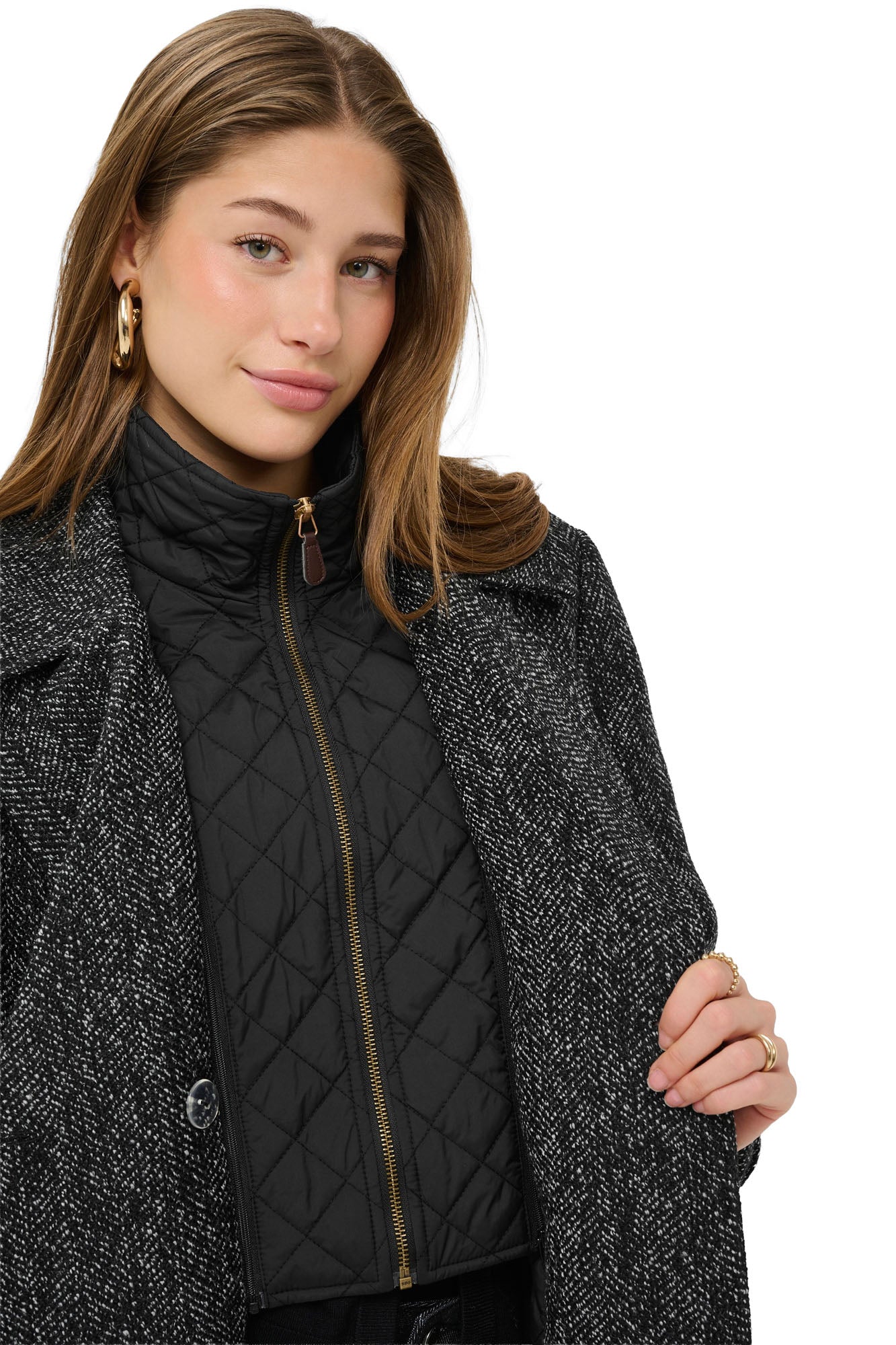 Cream women's black quilted zip bib under the black and white herringbone coat lapels, close view