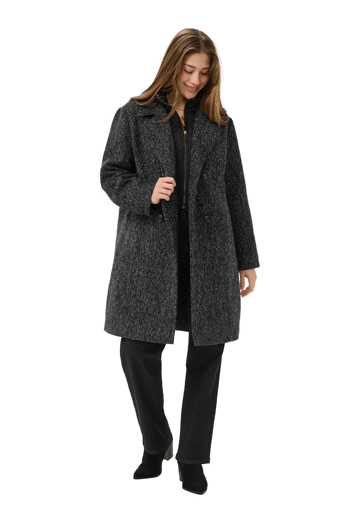 Women's angled front model view of black and white herringbone long coat worn open with quilted zip bib, side view by Cream