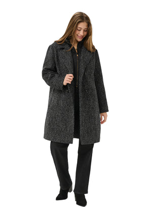 Women's angled front model view of black and white herringbone long coat worn open with quilted zip bib, side view by Cream