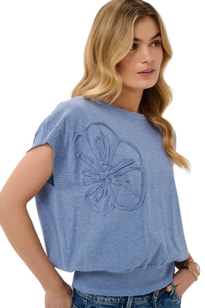 Cream women's light blue knit Short-sleeve T-Shirt showing raised tonal flower appliqué and ribbed sleeve, close view
