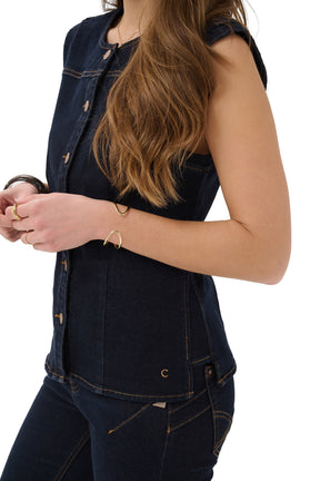 Women's angled close-up of dark indigo denim vest showing armhole, side seam, stitching and small C by Cream