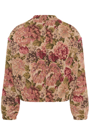 Cream women's cropped beige floral tapestry jacket with pink shoulder piping shown from the back