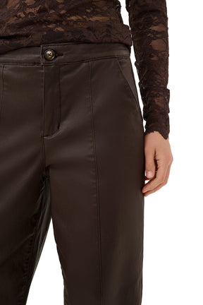 Cream women's dark brown faux-leather straight-leg pants waistband, button fly, pocket, and vertical seam, close-up