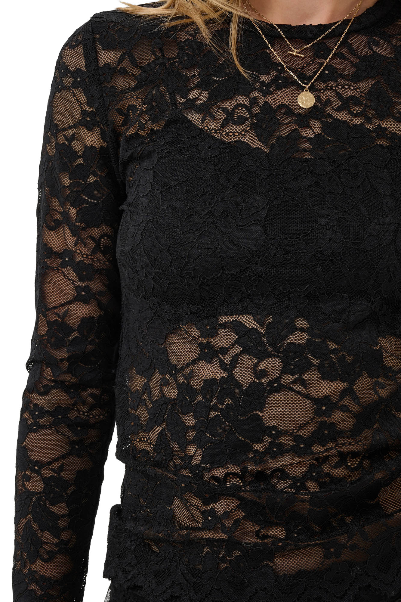 Women's close detail of black floral lace long-sleeve blouse showing sheer mesh, round neckline and raised motifs by Cream
