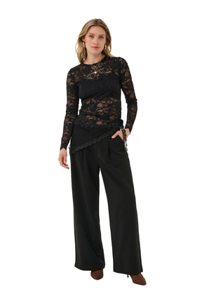 Cream women's full front model view of black floral lace long-sleeve blouse with round neck and long sheer sleeves