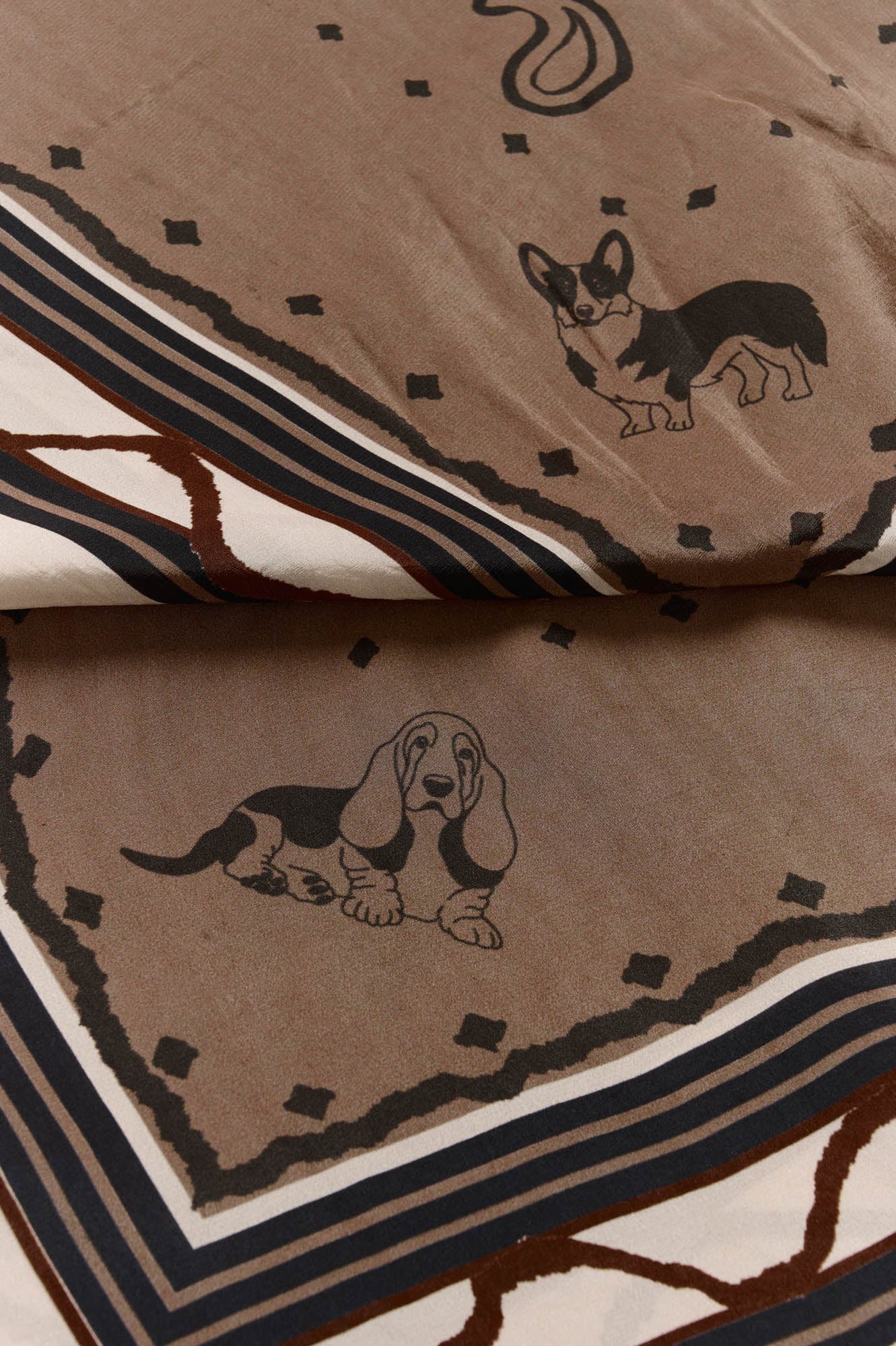 Women's close detail of taupe printed scarf with dog illustrations, dot motifs, and striped border by Cream
