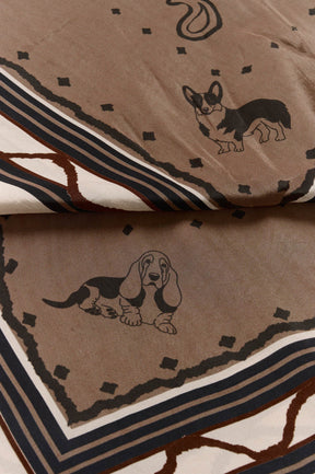 Women's close detail of taupe printed scarf with dog illustrations, dot motifs, and striped border by Cream