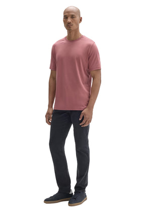 Men's angled full-body view of dusty pink crewneck Short-sleeve T-Shirt worn with dark pants, side view by Robert Barakett