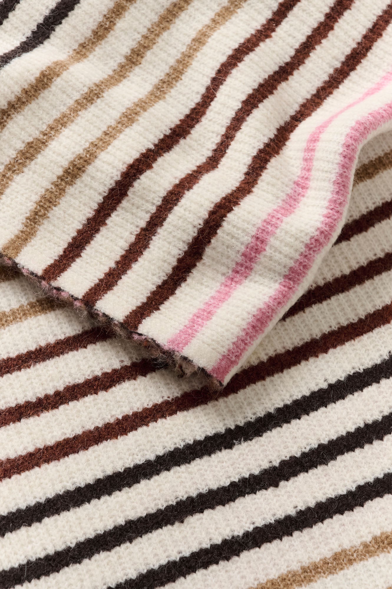 Gros plan de la texture en tricot ivoire du foulard à rayures brunes avec noires ainsi que tan et roses pour femme par InWear