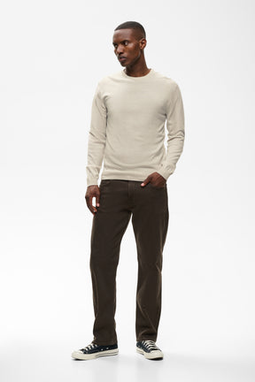 Men's angled front model view of the light beige crewneck knit long-sleeve knit sweater, side view by Matinique