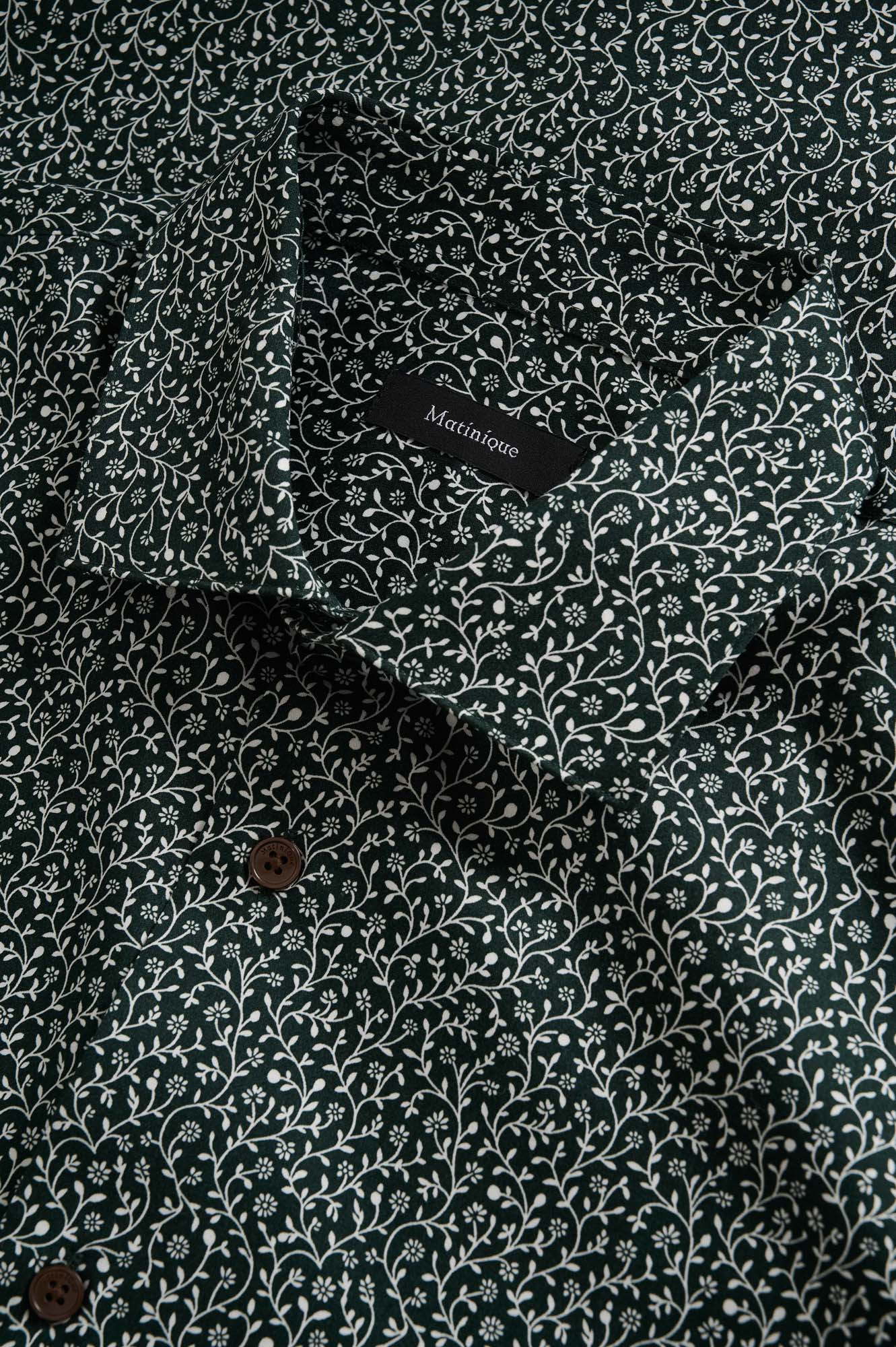 Matinique men's collar detail of dark green floral long-sleeve shirt with white vine print and brown buttons