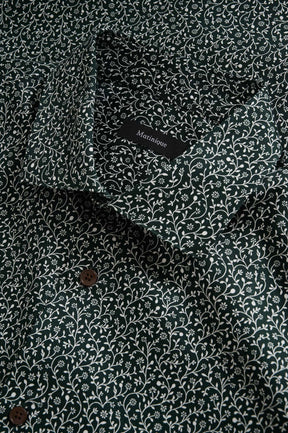 Matinique men's collar detail of dark green floral long-sleeve shirt with white vine print and brown buttons