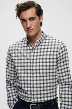 Men's close front model view of ivory and navy plaid long-sleeve shirt with button-down collar and chest pocket by Matinique