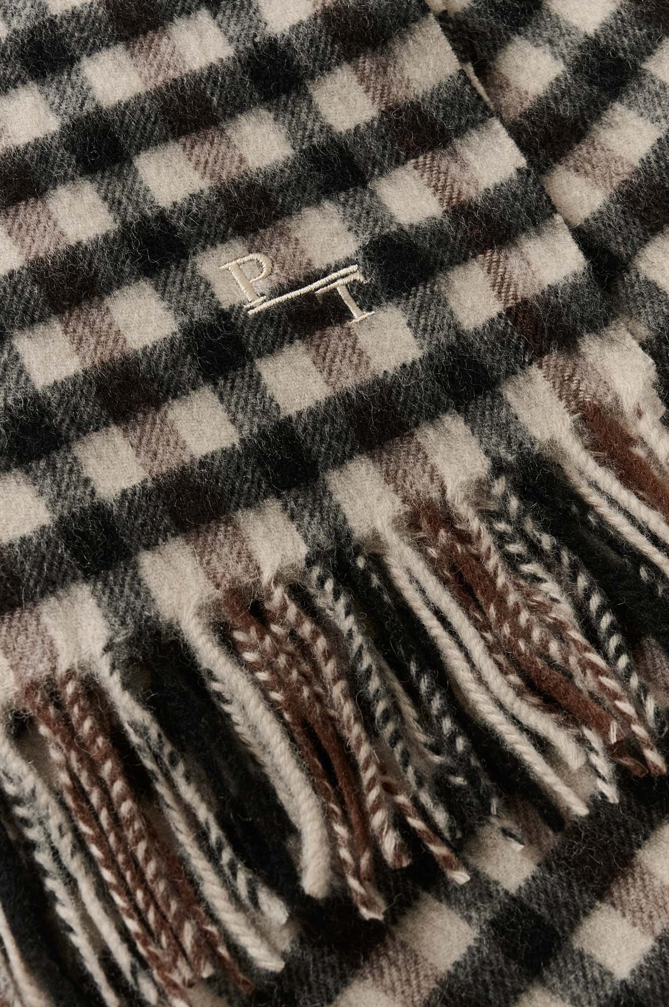 Foulard à carreaux beige et noir avec texture duveteuse ainsi que franges et monogramme PT brodé pour femme par Part Two en gros plan