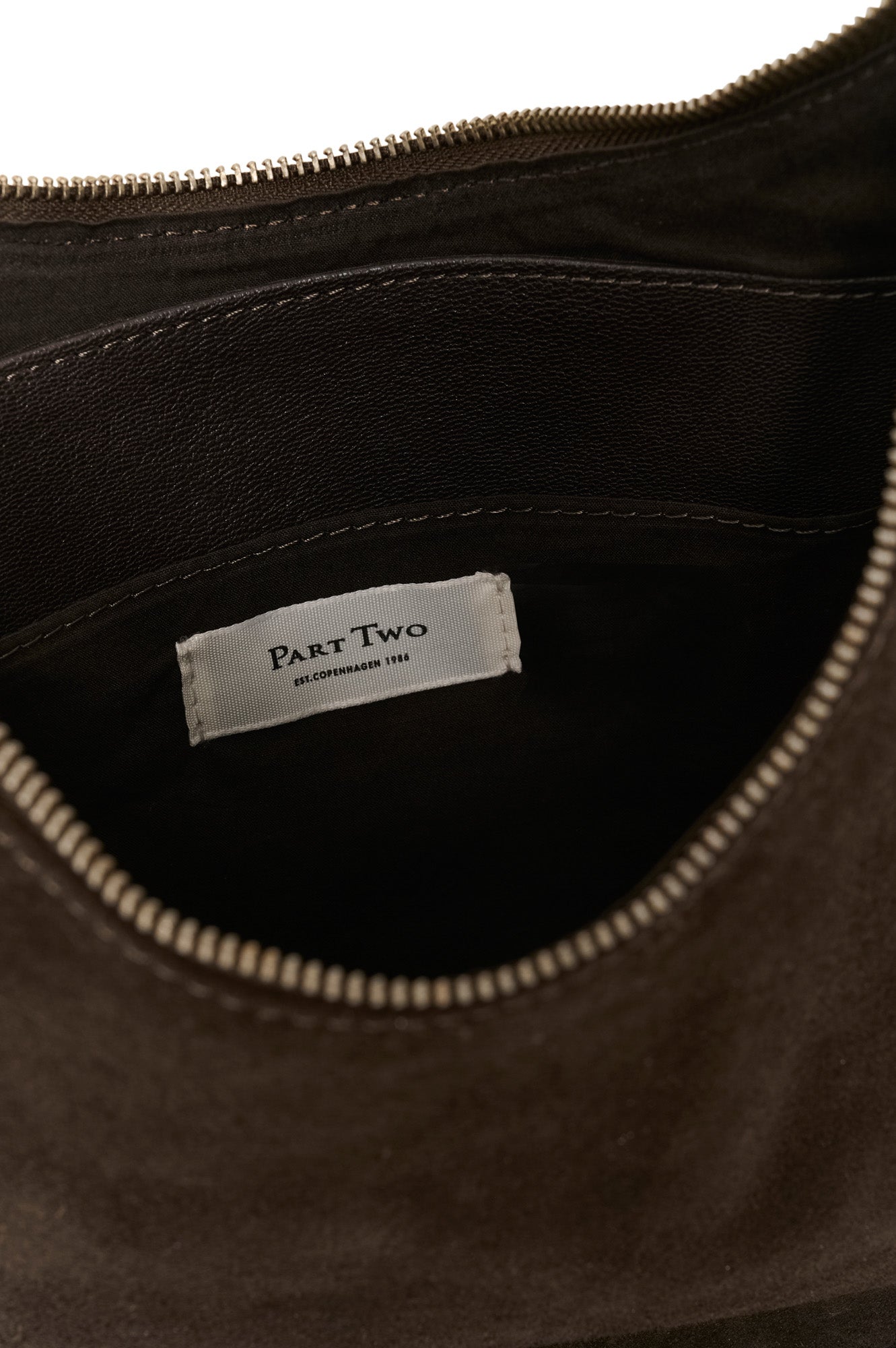 Détail intérieur de la sac à bandoulière brun foncé avec doublure noire et pochette pour femme par Part Two