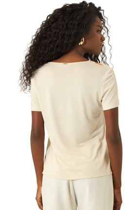 Vue arrière d'une blouse crème à manches courtes, dos uni et petite plaque métallique au col pour femme par Lez a Lez