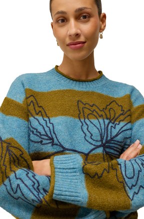 Close-up of women's ribbed crew neck on blue and olive knit long-sleeve knit sweater with floral embroidery by White Stuff