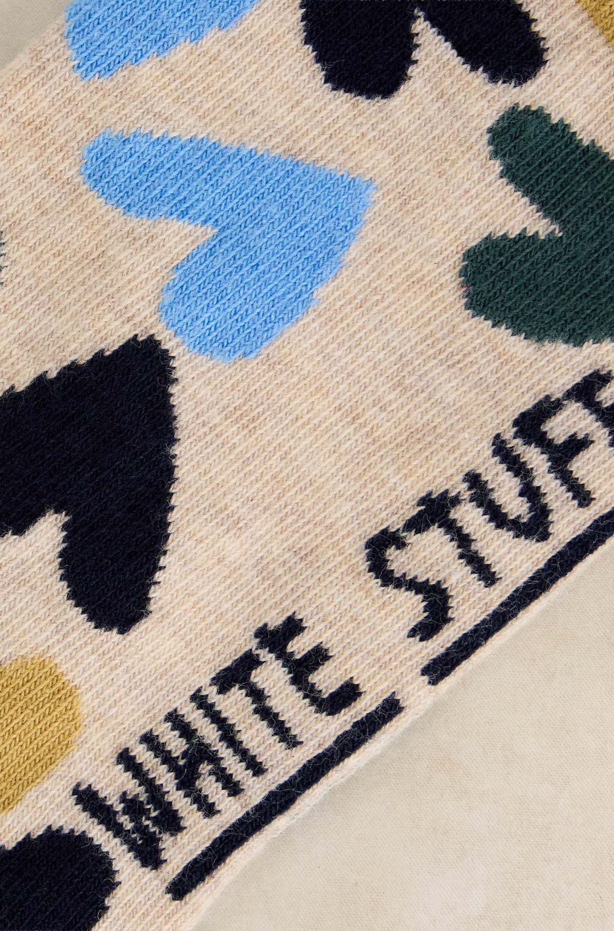 Bas crème avec coeurs bleus, marine et verts et texte foncé à la semelle pour femme par White Stuff, en gros plan