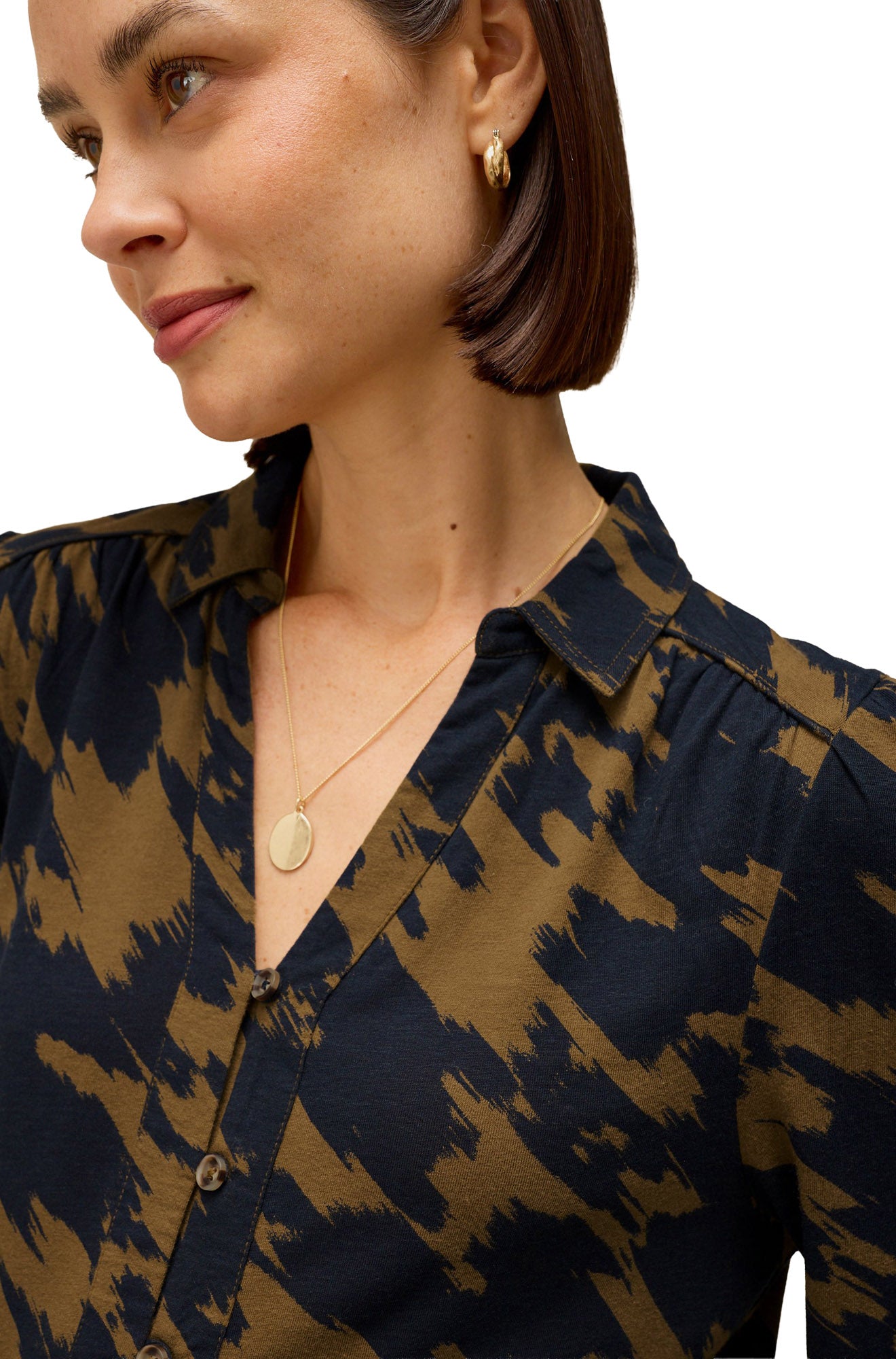 White Stuff women's close-up model view of olive and navy abstract print long-sleeve blouse with collar and button placket