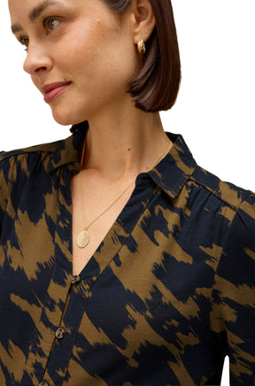 White Stuff women's close-up model view of olive and navy abstract print long-sleeve blouse with collar and button placket