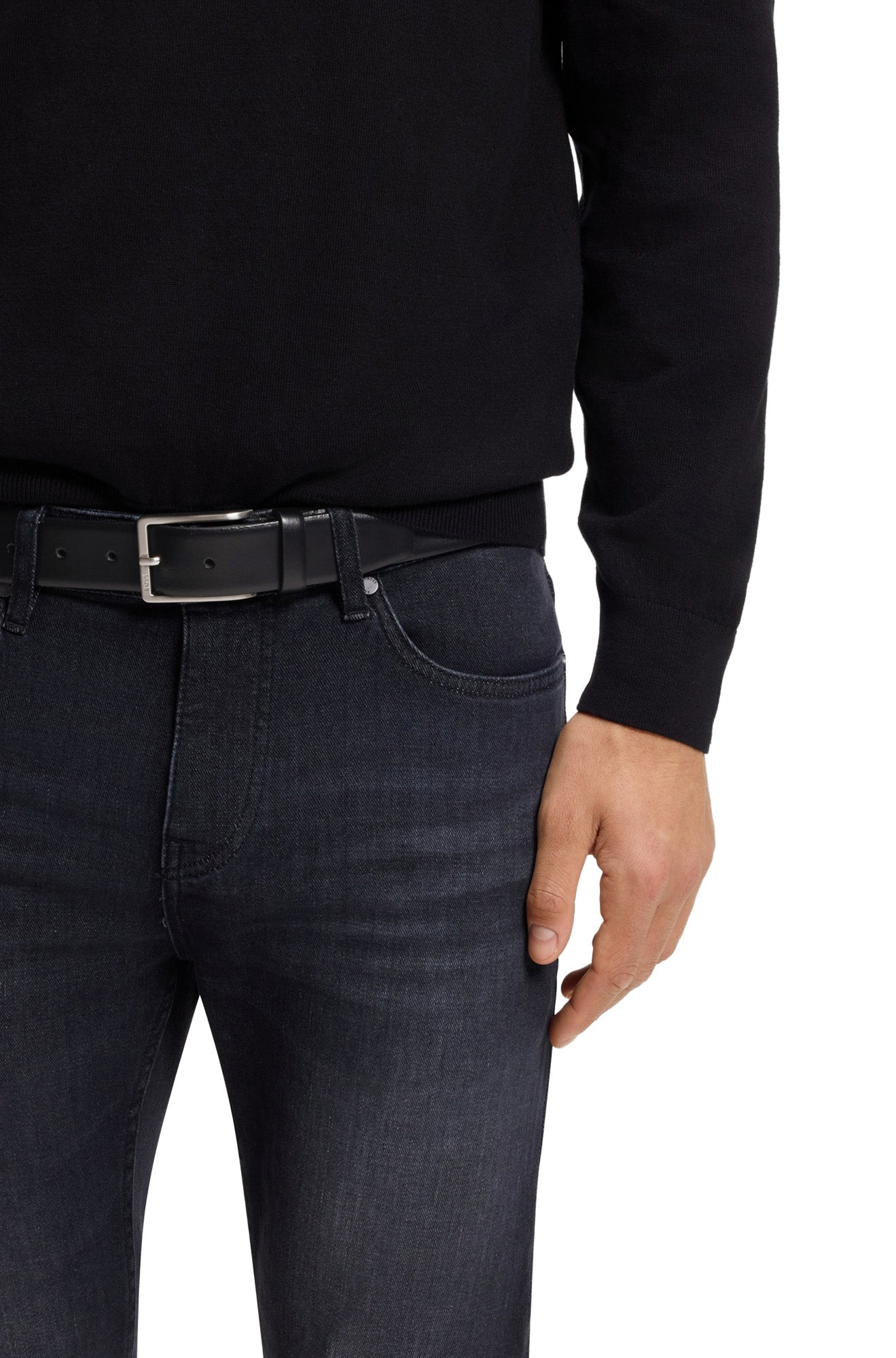 Ceinture en cuir noire portée avec jean foncé et boucle argentée, vue de face sur mannequin pour homme par HUGO BOSS