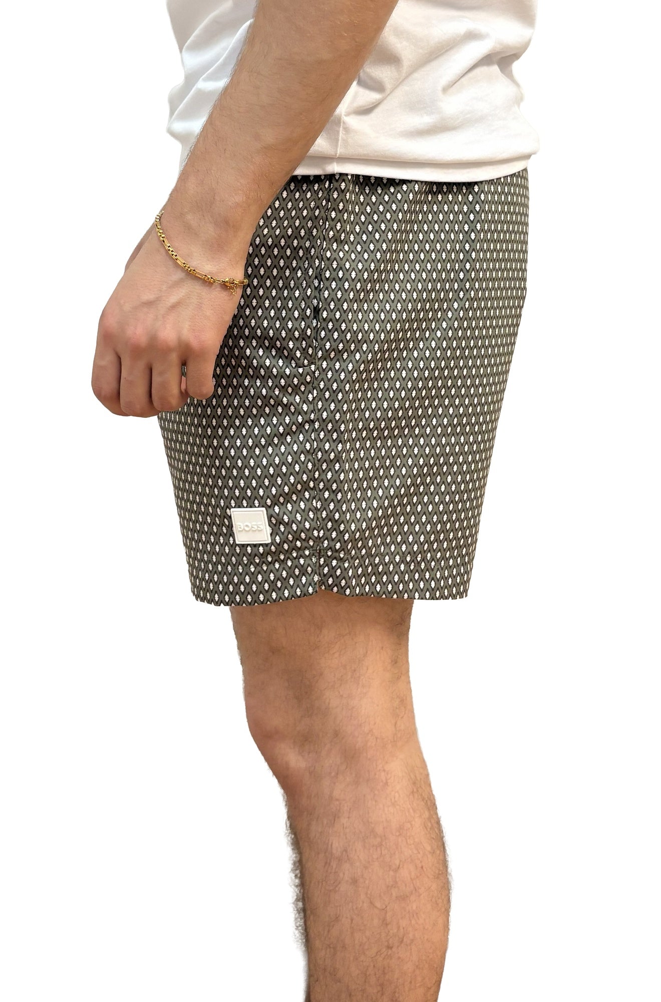 Vue de côté d’un short de bain foncé à motif diamant blanc et petit écusson logo pour homme par HUGO BOSS