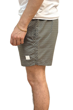Vue de côté d’un short de bain foncé à motif diamant blanc et petit écusson logo pour homme par HUGO BOSS