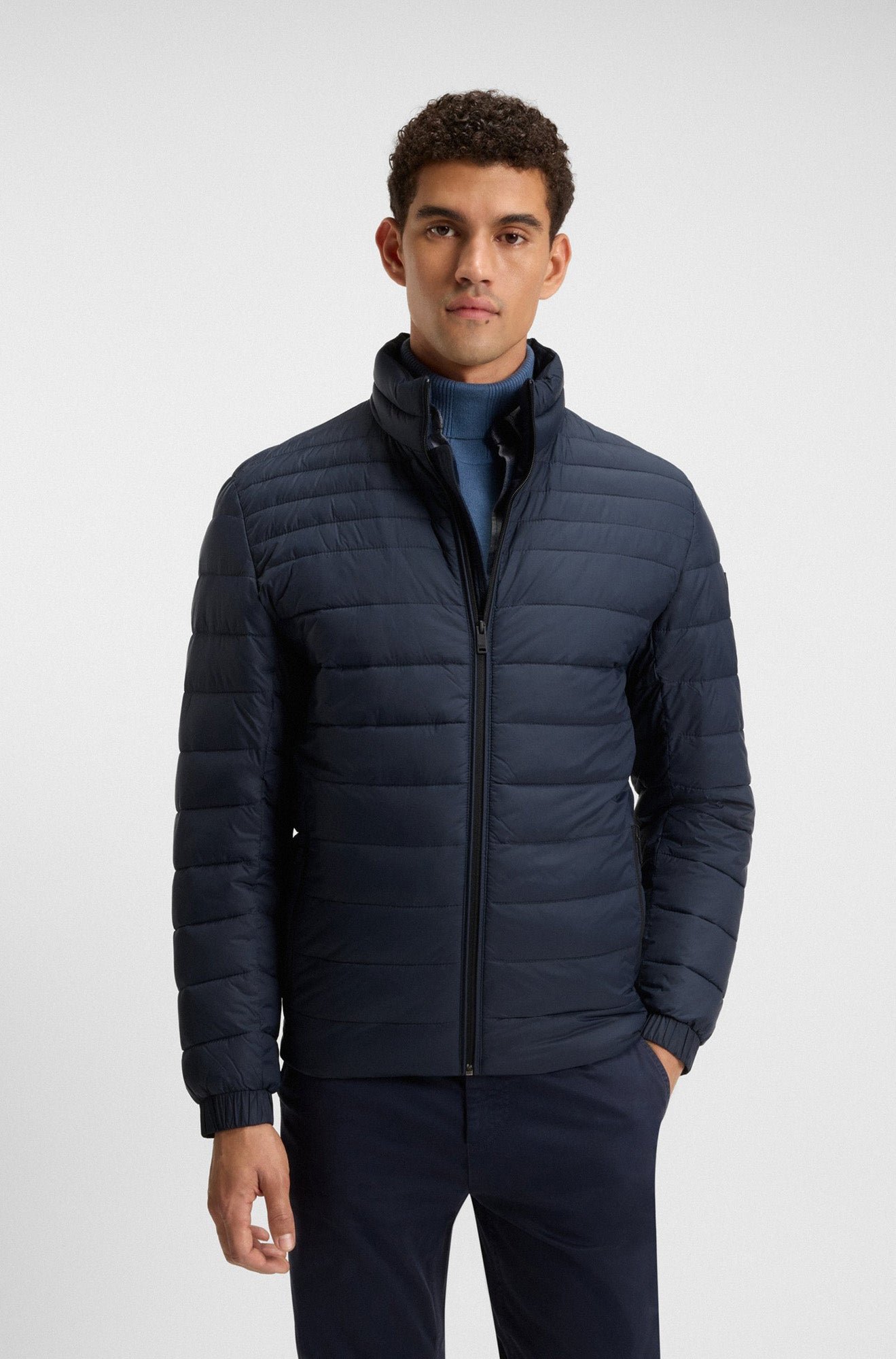 Manteau d'hiver matelassé marine avec col montant et poignets élastiques pour homme par HUGO BOSS, vue de face sur mannequin
