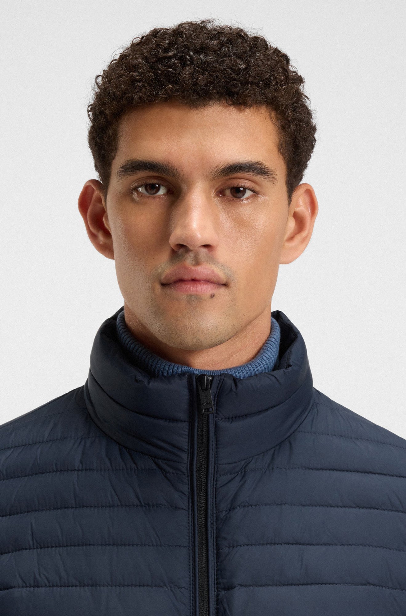 Manteau d'hiver matelassé marine avec col montant rembourré et fermeture noire pour homme par HUGO BOSS, en gros plan