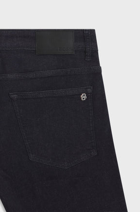 HUGO BOSS men's back waistband detail of dark black straight-leg jeans with BOSS patch, back pocket and small logo hardware