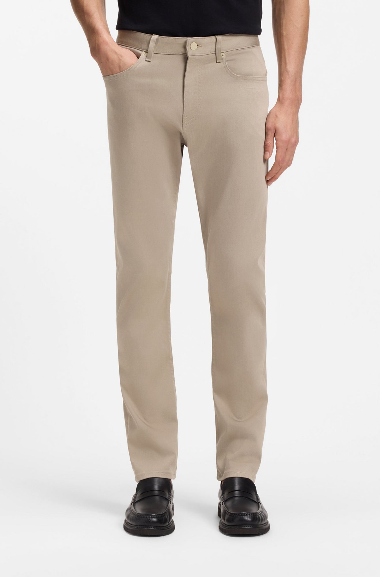 Vue avant sur modèle d’une jean à jambe droite beige droit avec style cinq poches et ourlets cousus pour homme par HUGO BOSS