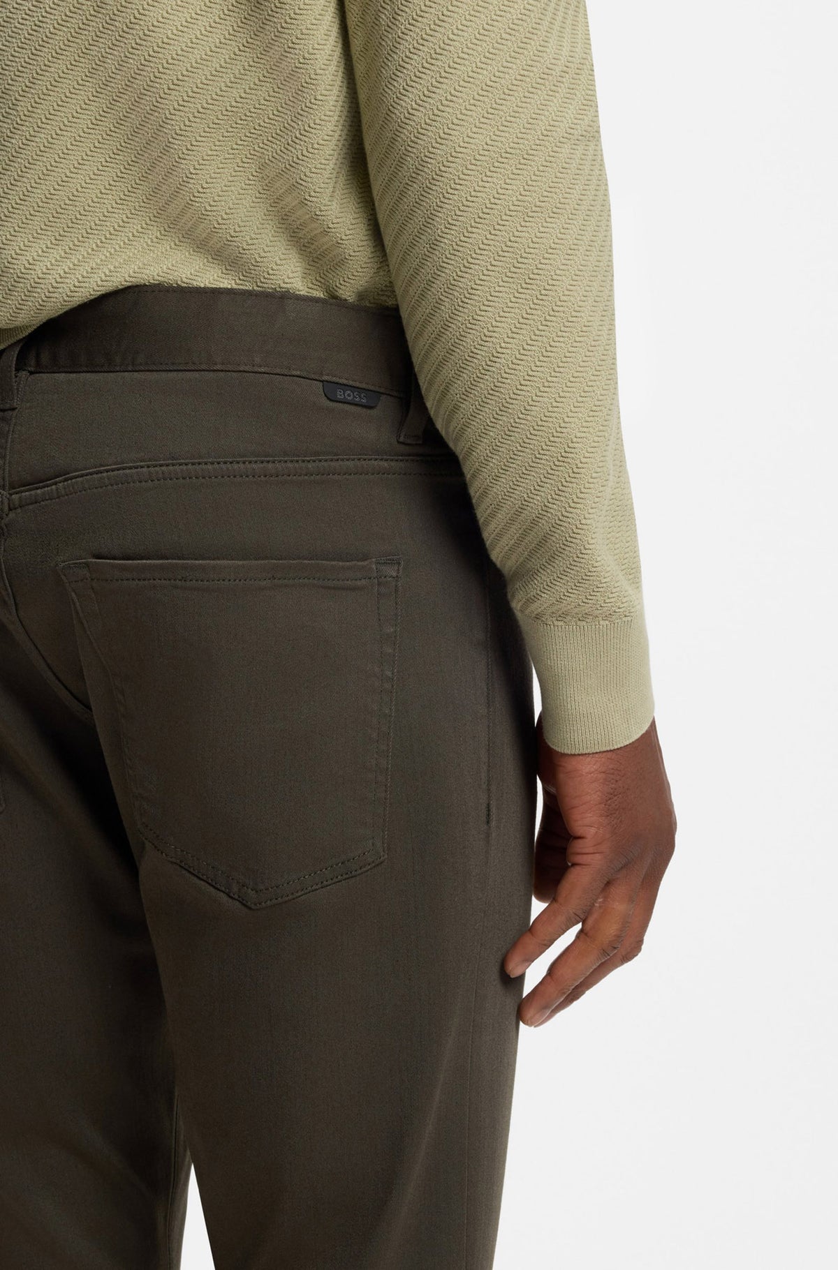 Gros plan arrière du jean droit vert olive sur modèle, poche plaquée et petite étiquette BOSS noire pour homme par HUGO BOSS
