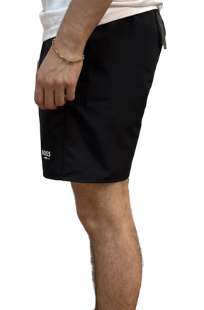 Vue de côté d’un short BOSS noir montrant la jambe lisse et le logo blanc près de l’ourlet pour homme par HUGO BOSS
